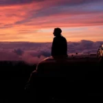 Mindful traveler journaling at sunrise, embracing transformative travel mindset